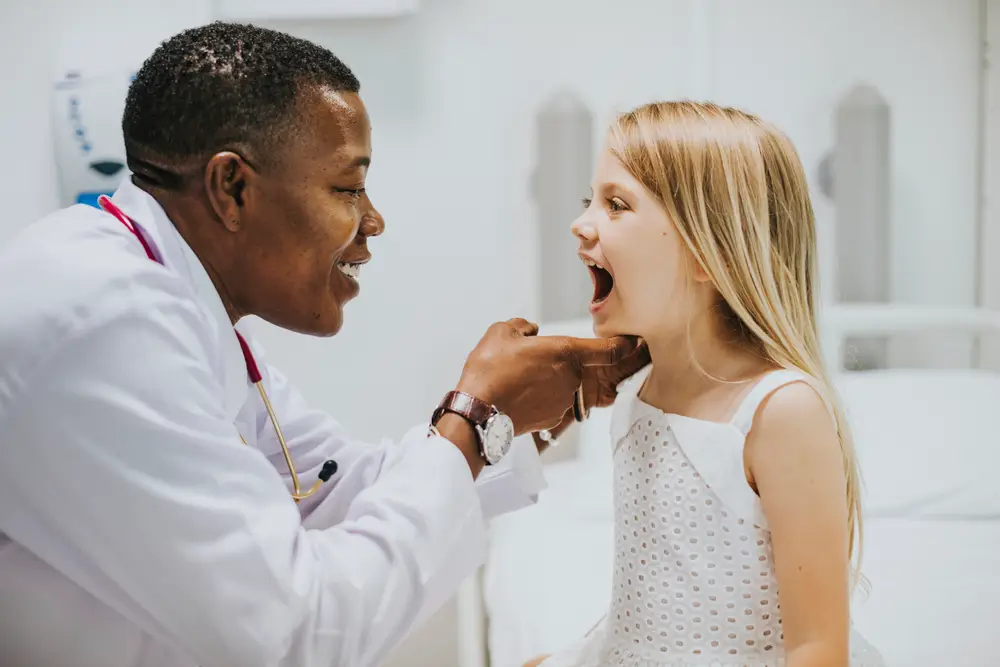 Young girl showing pediatric dentist her teeth